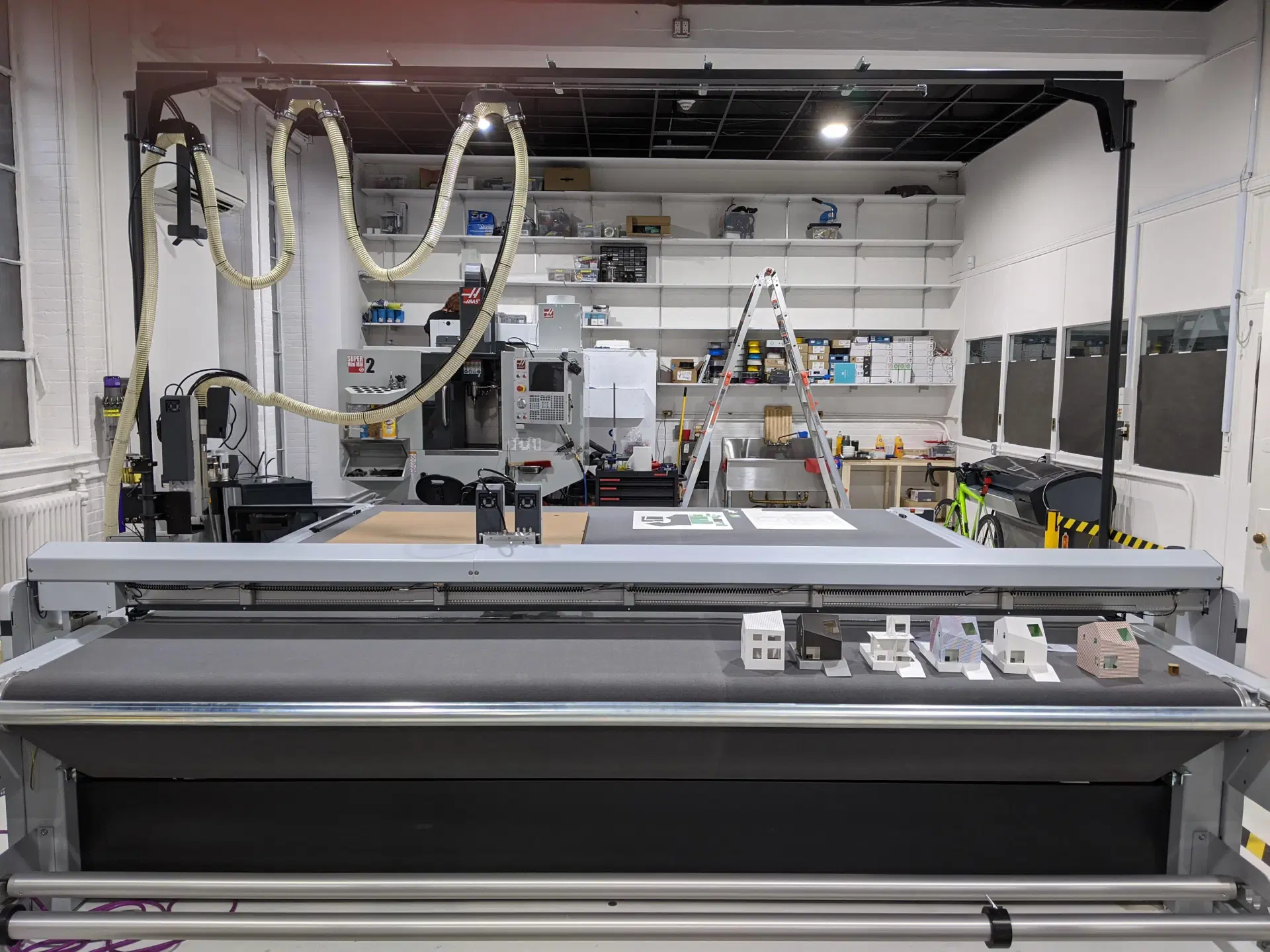 Workshop space with large digital fabrication machines, including a Zund cutter and Haas CNC mill